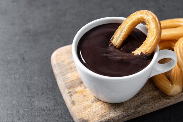 Traditionele Spaanse churros met warme chocolademelk op zwarte leisteen achtergrond