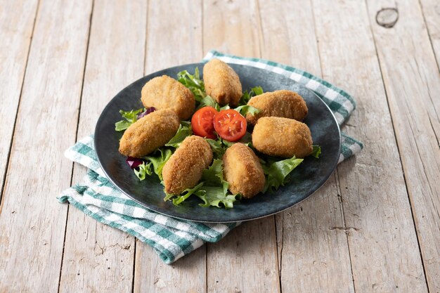 Traditionele spaanse gebakken kroketten op houten tafel