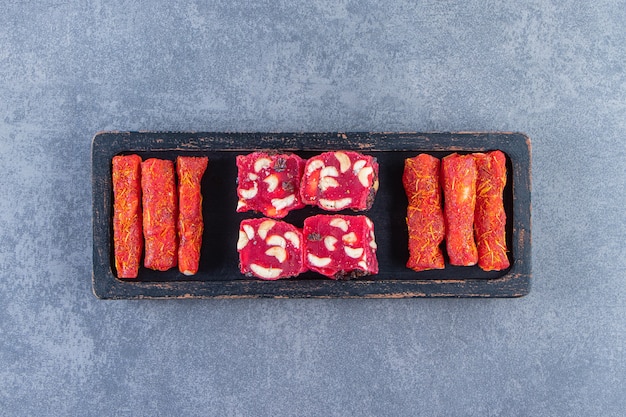 Gratis foto traditionele turkse lekkernijen op een houten bord op het marmeren oppervlak