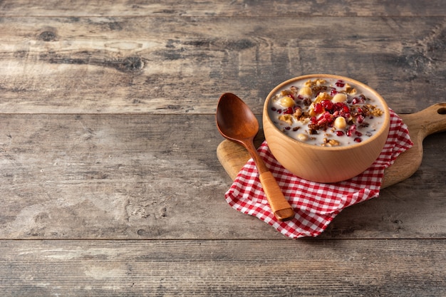 Gratis foto traditionele turkse noah's pudding in kom op houten tafel