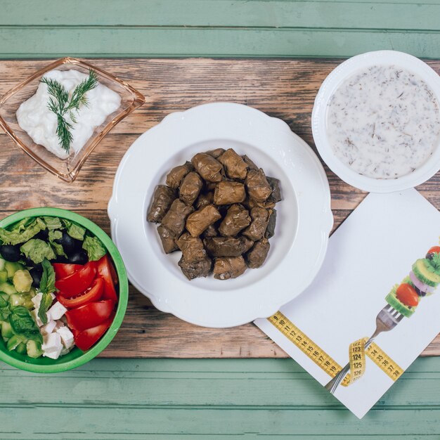 Traditionele yoghurtsoep en druivendolma met groentesalade.