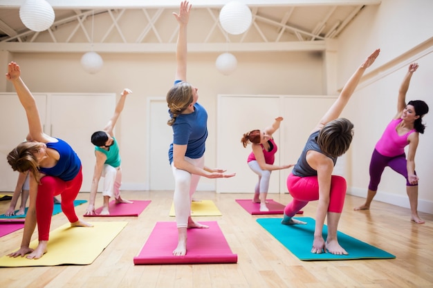 Trainer assisteren groep mensen met stretching oefening