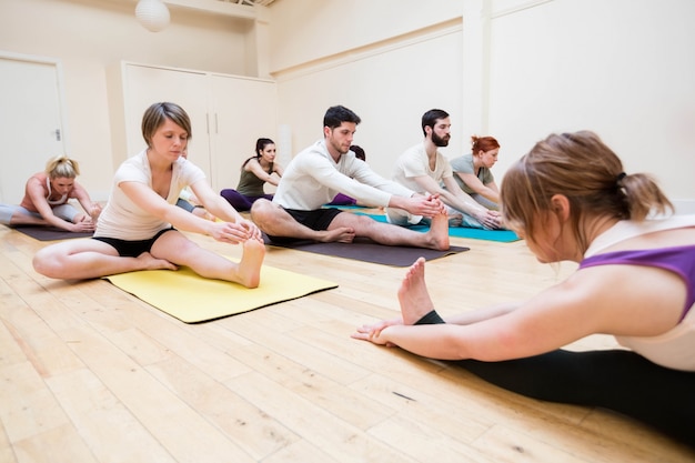 Trainer assisteren groep mensen met stretching oefening