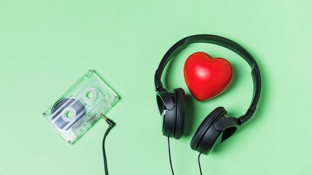 Transparante cassetteband die met hoofdtelefoon rond rood hart wordt verbonden