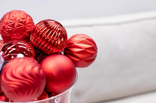 Transparante vaas met rode kerstballen op witte achtergrond selectieve focus kopie ruimte