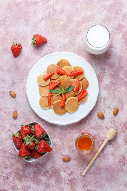 Trendy eten - mini-pannenkoekgranen. Hoop granen pannenkoeken met bessen en noten.