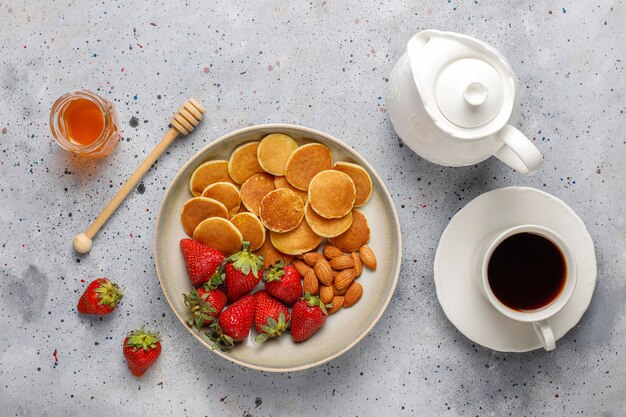 Trendy eten - mini-pannenkoekgranen. Hoop granen pannenkoeken met bessen en noten.