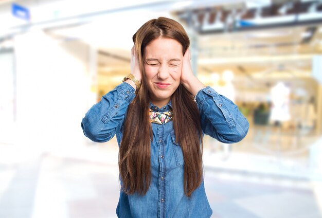 Trendy jonge vrouw op zoek geïrriteerd omdat een geluid