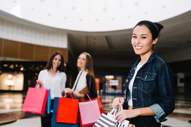 Trendy model met boodschappentassen in het winkelcentrum