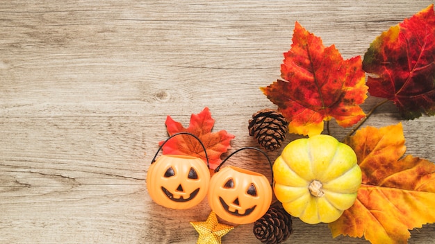 Trick or treat emmers en pompoen in de buurt van bladeren en kegels