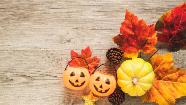 Trick or treat emmers en pompoen in de buurt van bladeren en kegels