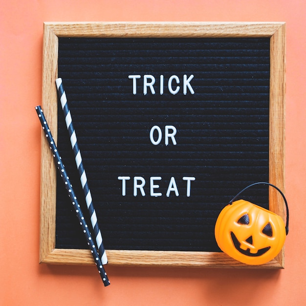 Gratis foto trick or treat mand en rietjes op frame met schrijven