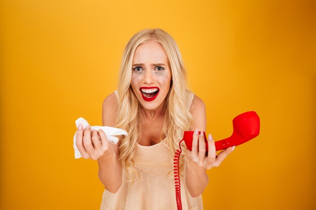 Triest huilende schreeuwende jonge blonde vrouw praten via de telefoon.