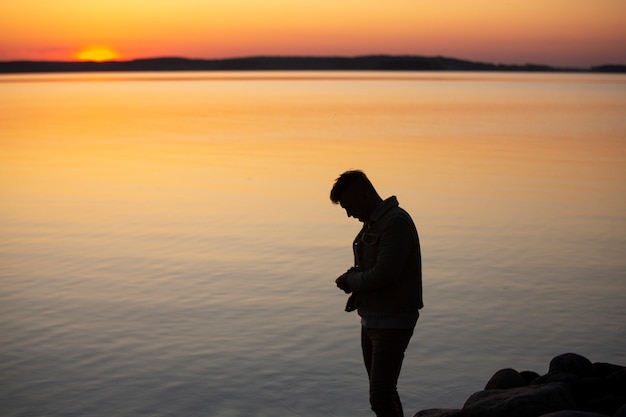 Gratis foto trieste en contemplatieve persoon in de buurt van het meer