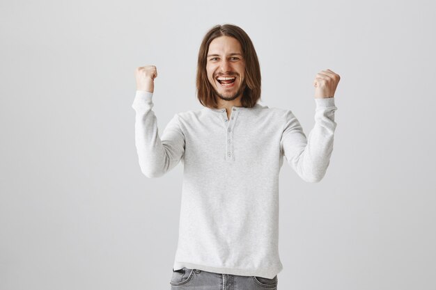 Triomfen gelukkig bebaarde man vuist pomp, overwinning vieren