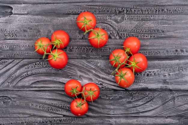 trossen van rode tomaten bovenaanzicht op zwart hout