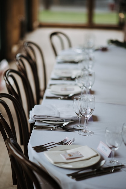 Trouwdag versierde tafel met borden, servetten, wijnglazen, vorken en messen