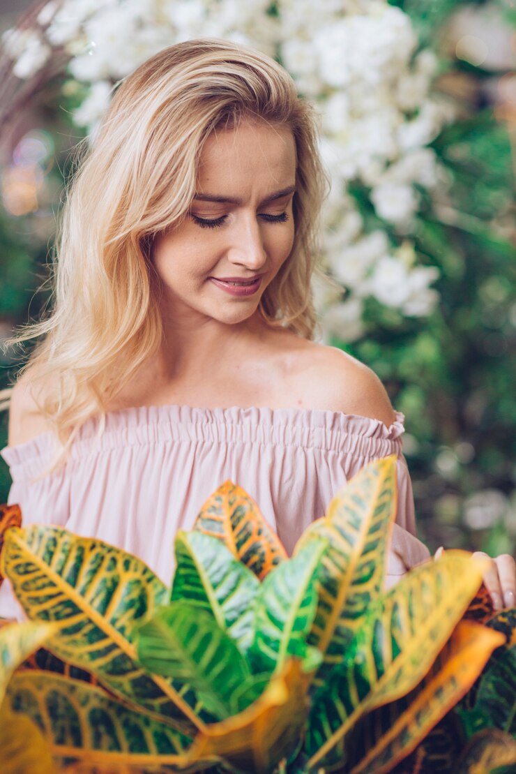 Gratis Foto tuincroton voor blonde jonge vrouw in openluchttuin