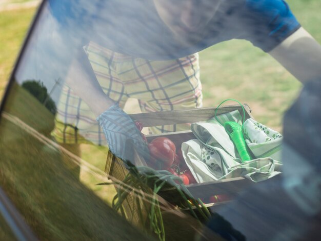 Tuinman die de plantaardige kist in de auto houdt