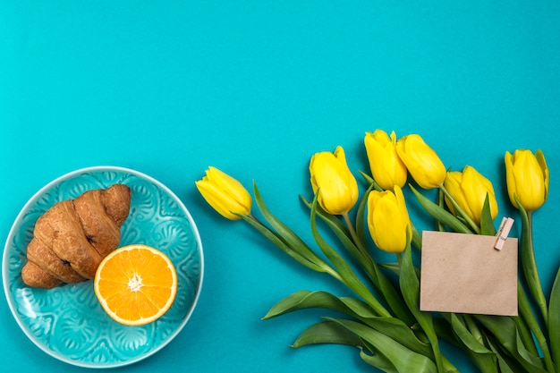 Tulpen met blanco papier en croissant