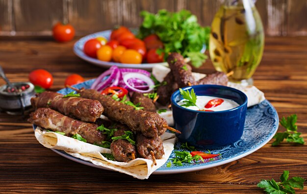 Turkse en Arabische traditionele Ramadan mix kebab plaat. Kebab adana, kip, lam en rundvlees op lavashbrood met saus. Bovenaanzicht