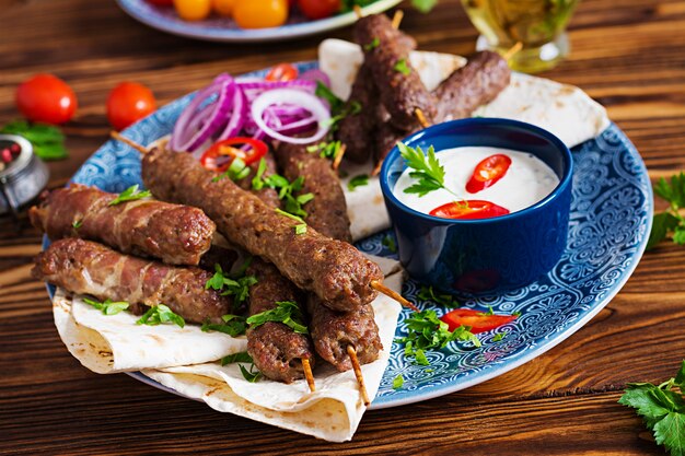 Turkse en Arabische traditionele Ramadan mix kebab plaat. Kebab adana, kip, lam en rundvlees op lavashbrood met saus. Bovenaanzicht