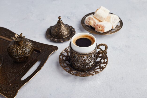 Turkse koffieset geserveerd met lokum in metalen schotel.