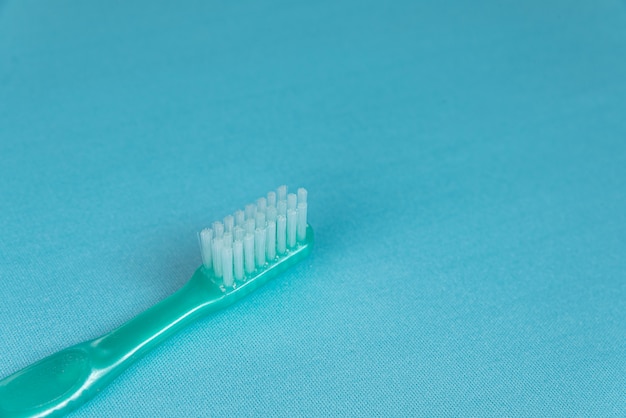 Turquoise tandenborstel op het blauwe oppervlak
