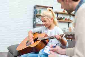 Gratis foto tutor en jonge student leren gitaar spelen