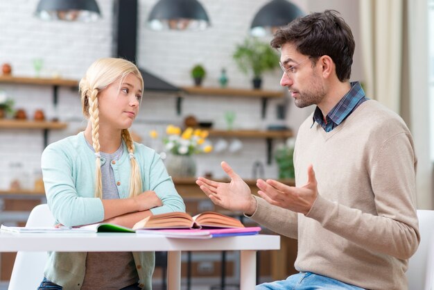 Tutor en meisje zitten aan de tafel