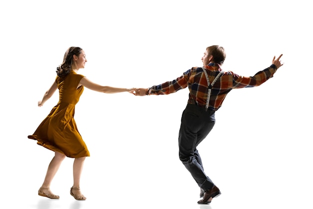 Gratis foto twee actieve dansers, man en vrouw, trainen boogie woogie-dans geïsoleerd over witte muur