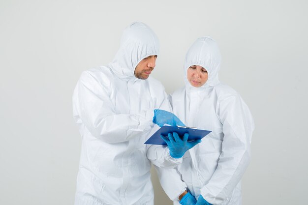 Twee artsen bespreken resultaten van laboratoriumtests in beschermend pak