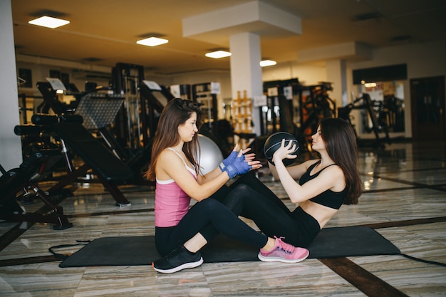 Twee atletische meisjes in de sportschool