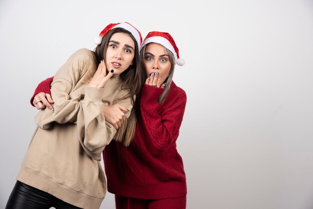 Twee bange jonge meisjes gekleed in warme truien kijken en schreeuwen.