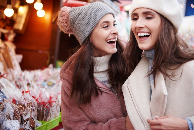 Twee beste vrienden die plezier hebben op de kerstmarkt