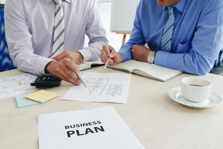 Gratis Foto twee bijgesneden startuppers die een businessplan ontwikkelen