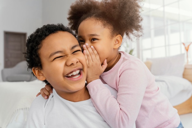 Gratis foto twee broers en zussen vertellen elkaar thuis geheimen