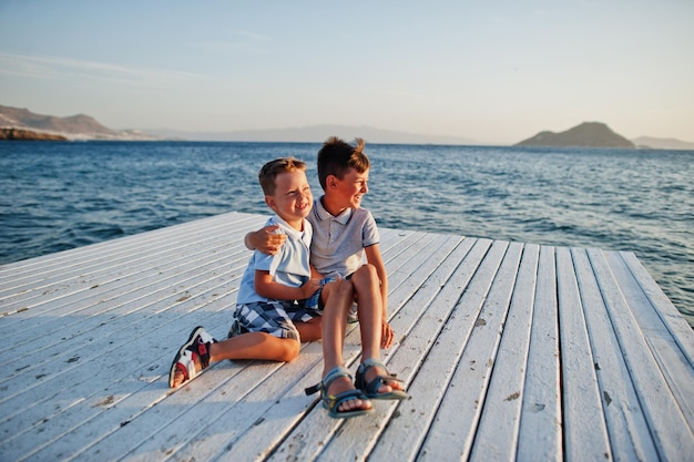 Twee broers zitten in het resort van Turkije op de pier tegen de Middellandse Zee