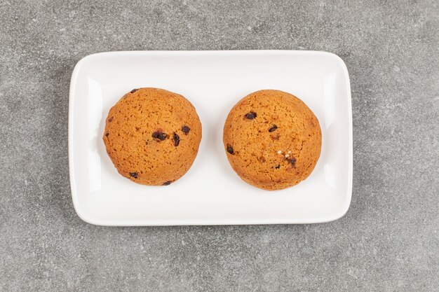 Twee chocoladekoekjes op witte plaat.