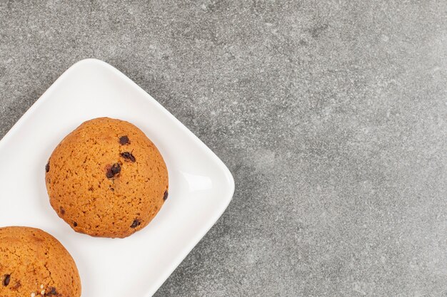 Twee chocoladekoekjes op witte plaat.