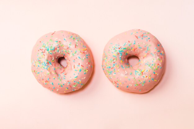 Twee donuts met kleurrijke hagelslag schikte op achtergrond