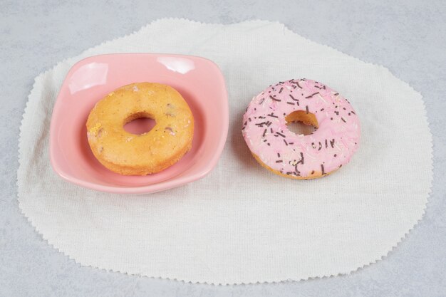 Twee donuts met sproeiers op marmeren tafel. Hoge kwaliteit foto