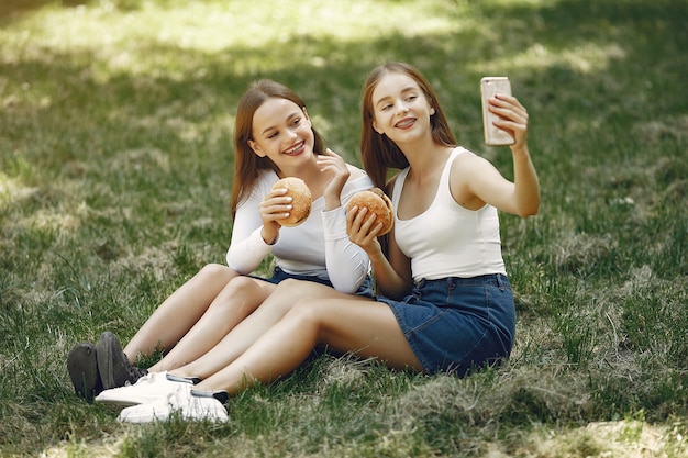Twee elegante en stijlvolle meisjes in een lentepark
