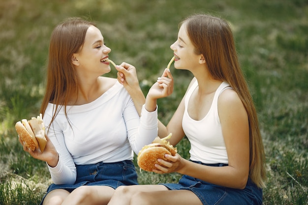 Twee elegante en stijlvolle meisjes in een lentepark