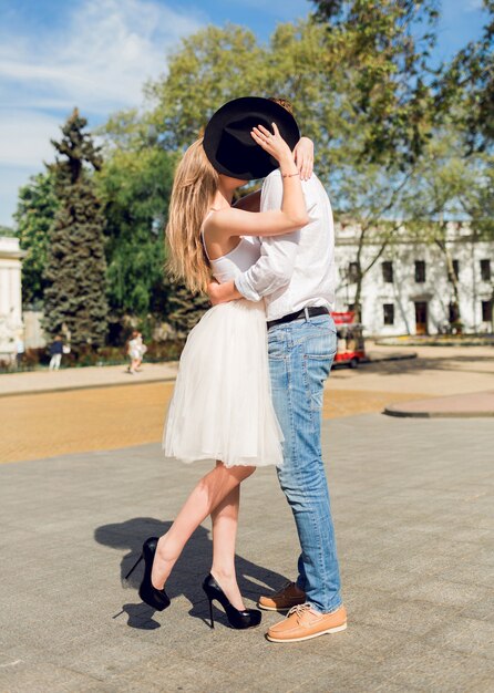 twee geliefden, geweldig paar in witte lente-outfit knuffelen op straat