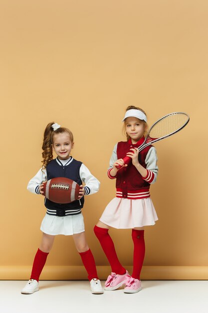 Twee gelukkige en mooie kinderen tonen verschillende sporten. Emoties concept.