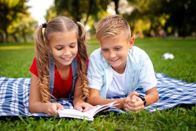 Twee gelukkige kinderen die op een deken liggen