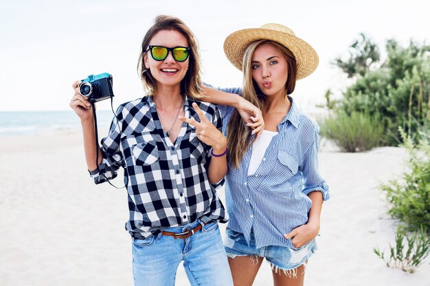 Twee gelukkige vriendinnen met plezier op het strand