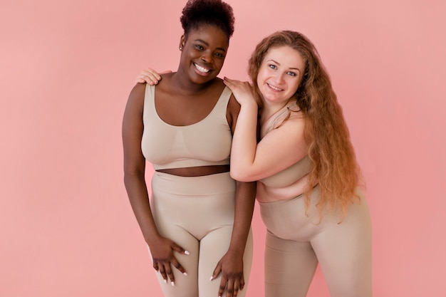 Twee gelukkige vrouwen poseren terwijl ze een bodyshaper dragen