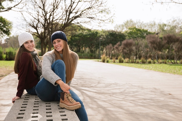 Twee glimlachende vrouwen die op een bank zitten